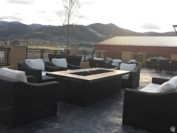 View of patio with an outdoor living space with a fire pit and a mountain view