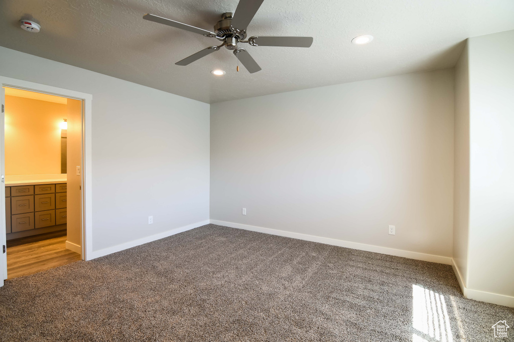Interior space featuring carpet, ensuite bathroom, and ceiling fan