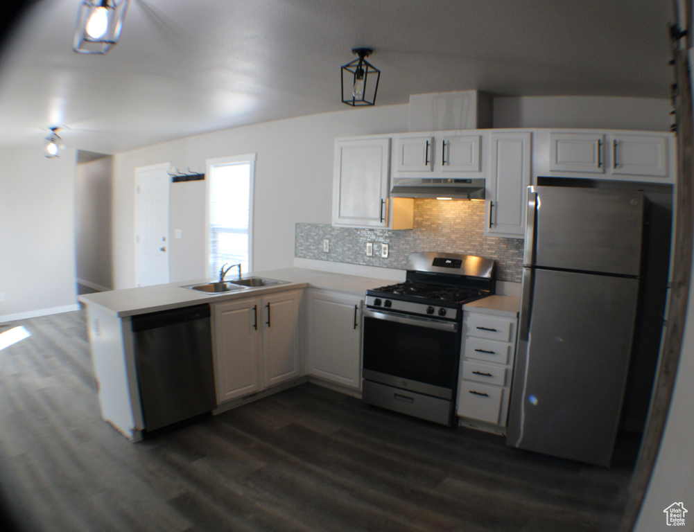 Kitchen with dark wood-type flooring, tasteful backsplash, stainless steel appliances, and sink