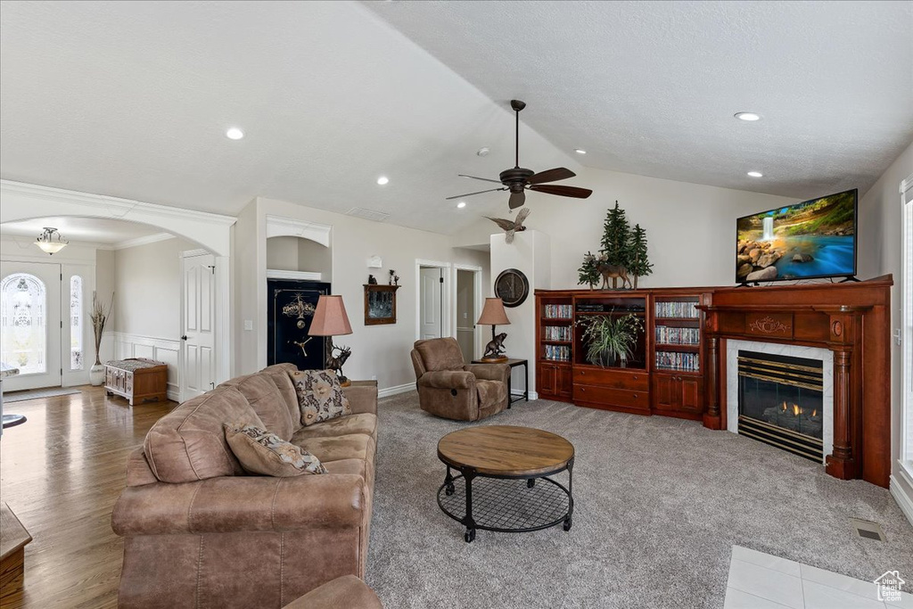Living room with vaulted ceiling, light hardwood / wood-style floors, and ceiling fan