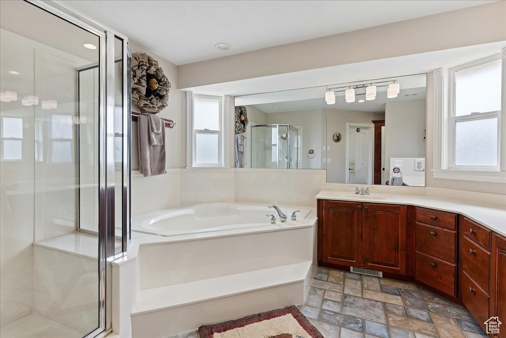 Bathroom with vanity, plenty of natural light, shower with separate bathtub, and tile floors
