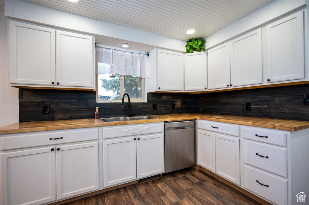 Kitchen with dark hardwood / wood-style floors, tasteful backsplash, white cabinetry, and dishwasher
