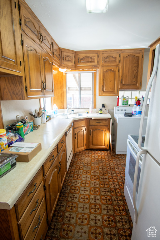 Kitchen with white appliances, sink, and dark tile flooring