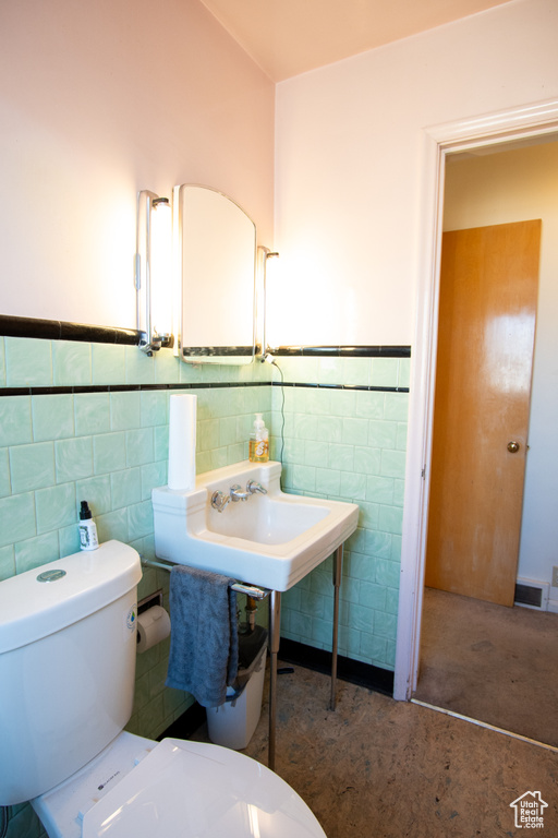 Bathroom with tile walls and toilet