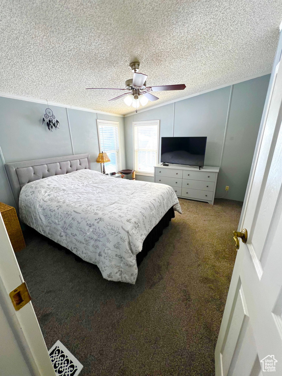 Bedroom with carpet floors, a textured ceiling, and ceiling fan