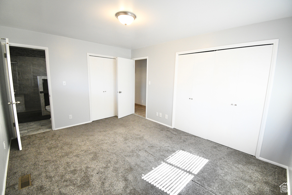 Unfurnished bedroom featuring carpet flooring and ensuite bath
