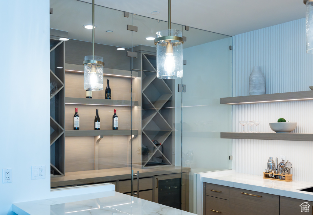Interior space featuring hanging light fixtures, gray cabinetry, and light stone counters