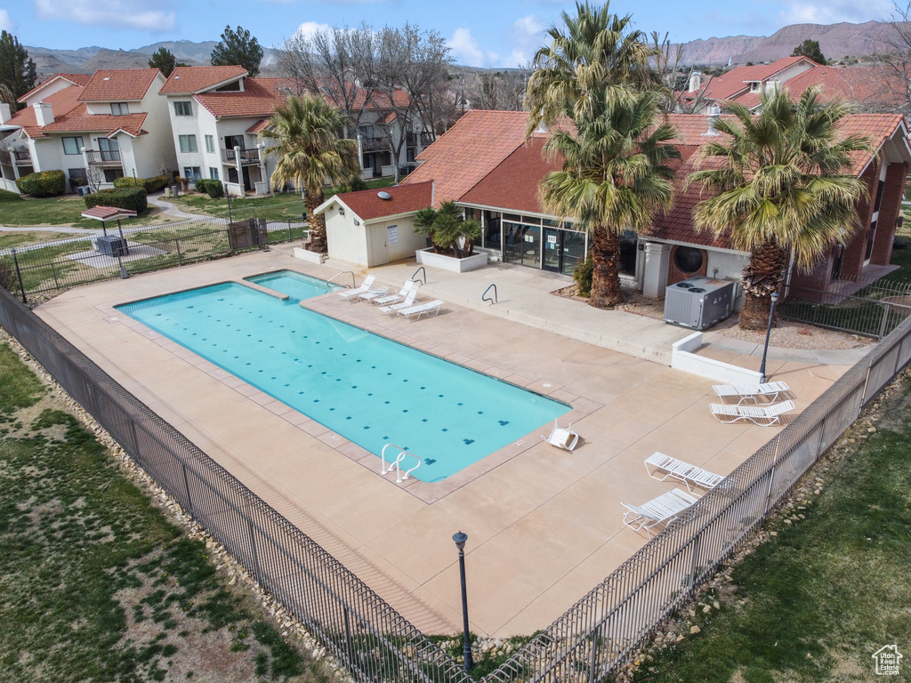 View of swimming pool with a patio area, a mountain view, and central AC