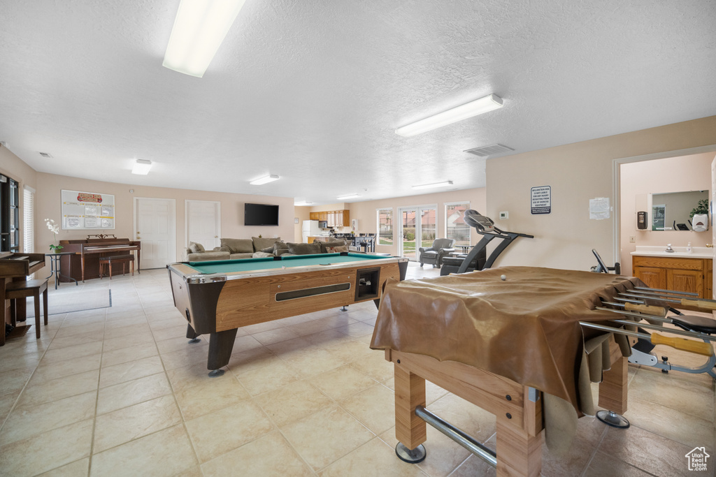 Playroom with light tile floors, a textured ceiling, billiards, and sink