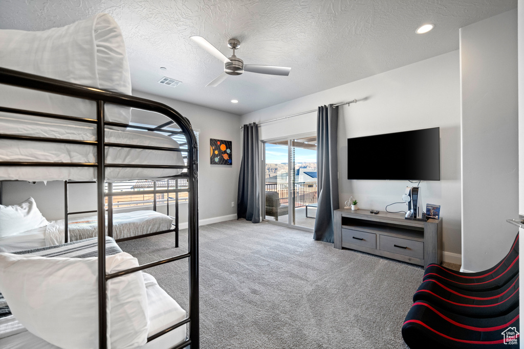 Bedroom featuring a textured ceiling, access to exterior, light carpet, and ceiling fan