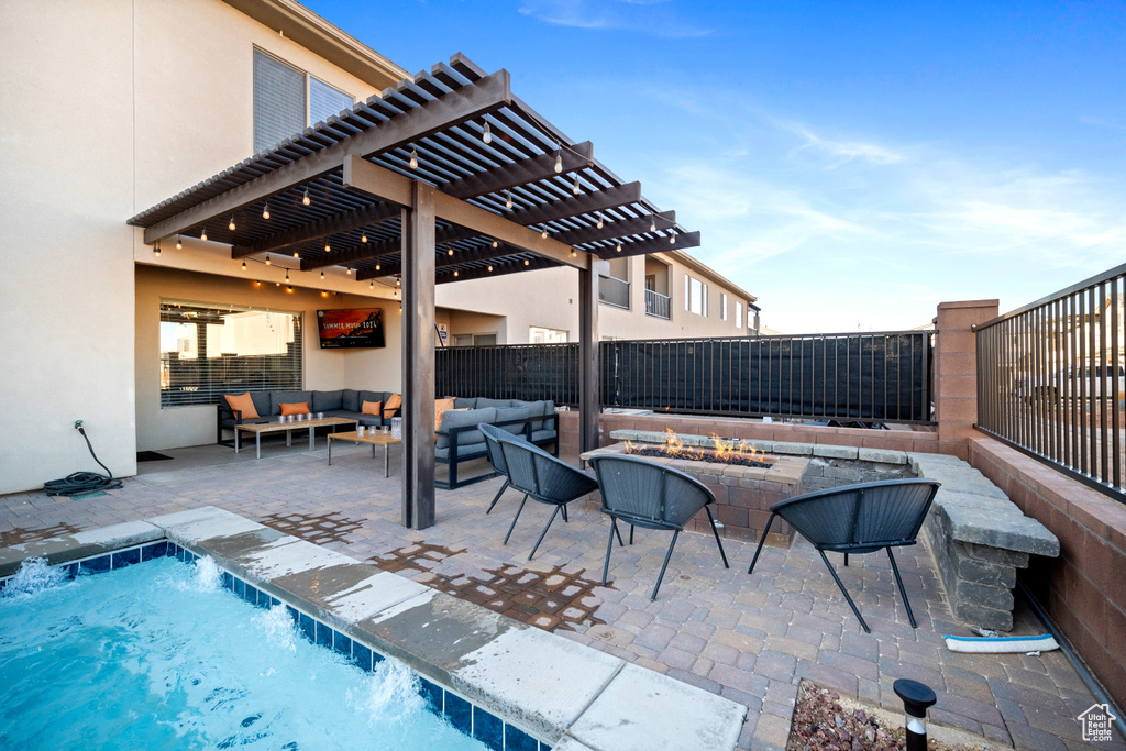 View of swimming pool with a pergola, a patio area, and an outdoor living space with a fire pit
