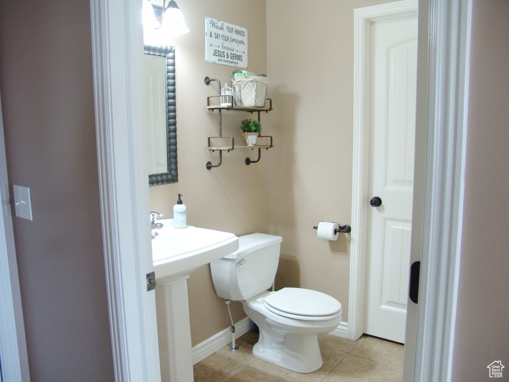 Bathroom with toilet, tile flooring, and sink