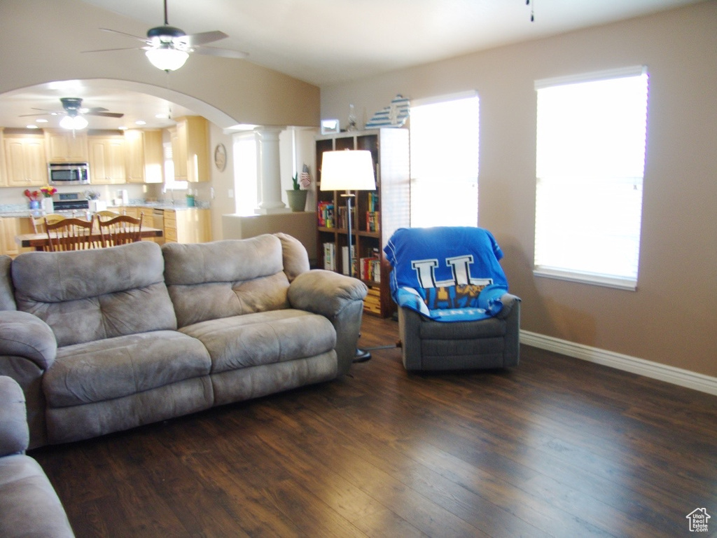 Living room featuring ornate columns, dark hardwood / wood-style flooring, and ceiling fan