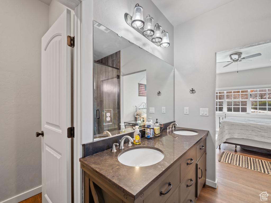 Bathroom with hardwood / wood-style flooring, double vanity, and ceiling fan