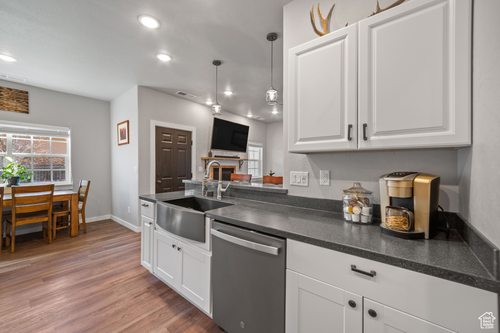 Kitchen featuring white cabinets, sink, dishwasher, and light hardwood / wood-style flooring
