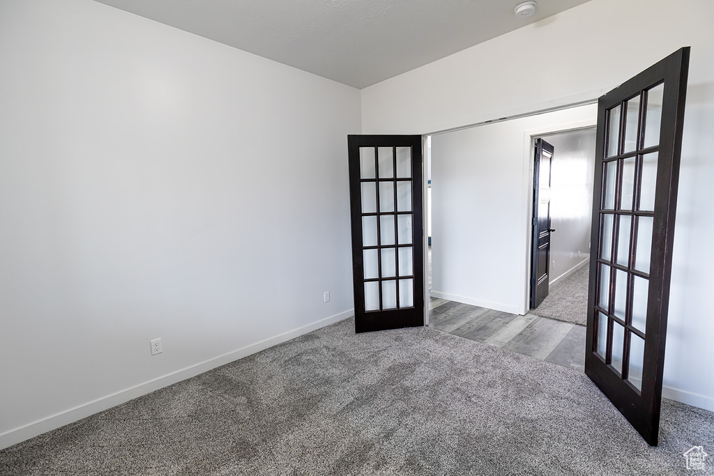 Unfurnished room featuring dark wood-type flooring and french doors