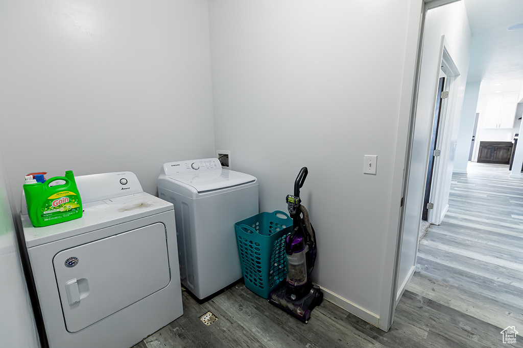 Laundry area with independent washer and dryer and hardwood / wood-style floors