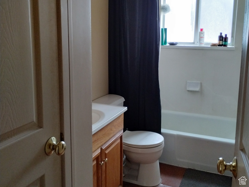 Full bathroom with vanity, a textured ceiling, shower / bath combo, toilet, and tile floors
