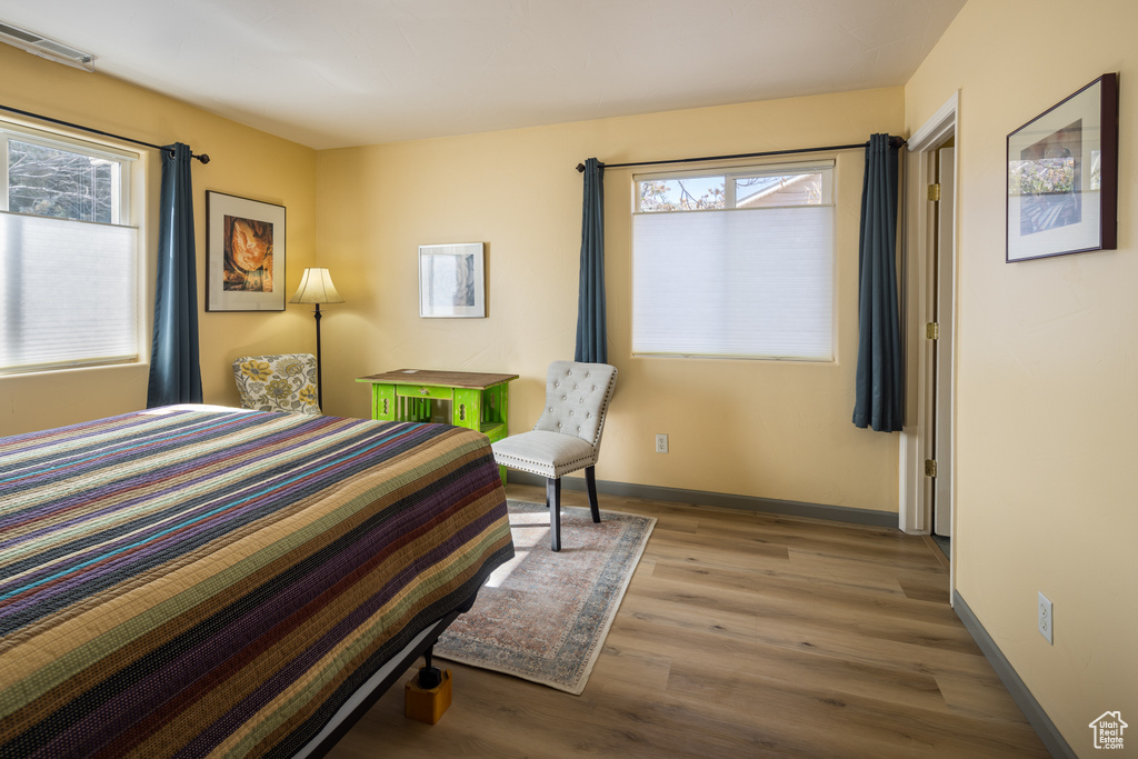 Bedroom with multiple windows and light hardwood / wood-style flooring