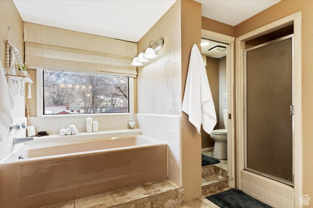Bathroom featuring toilet, tile flooring, and plus walk in shower