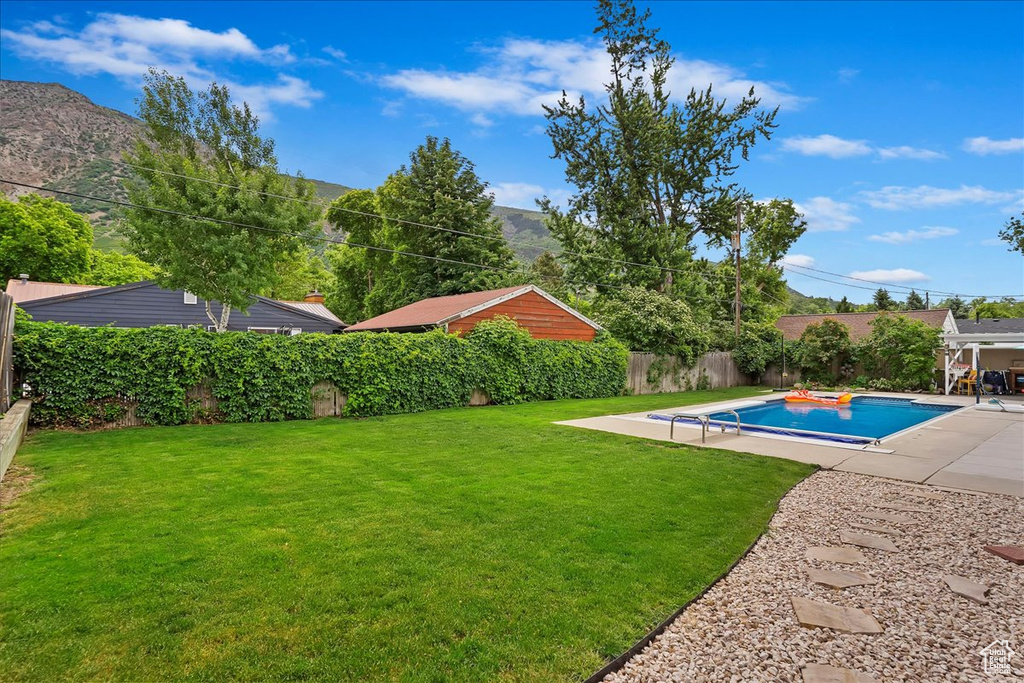 View of yard with a patio area, a fenced in pool, and a mountain view