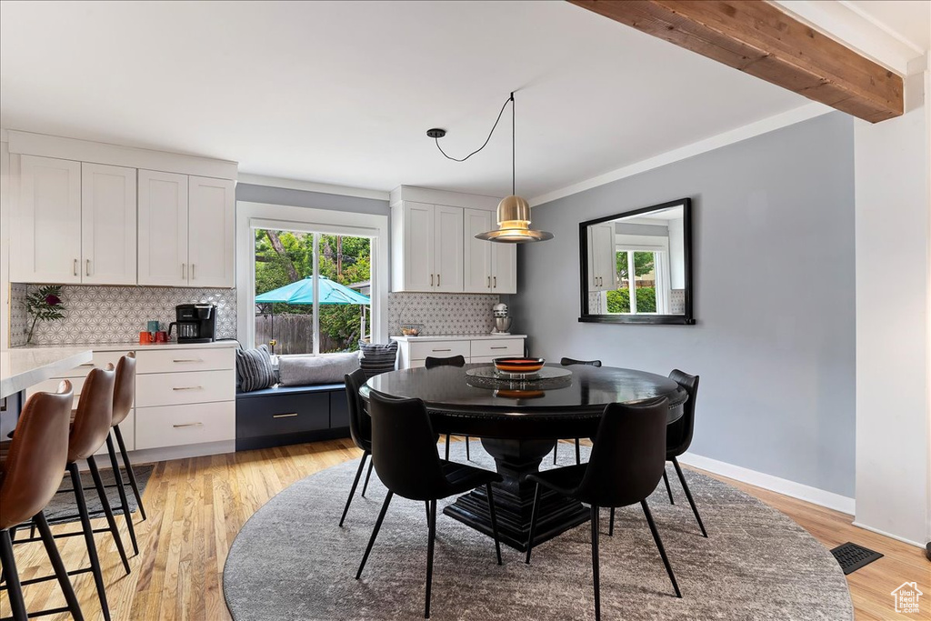 Dining room featuring ornamental molding, beam ceiling, and light hardwood / wood-style floors