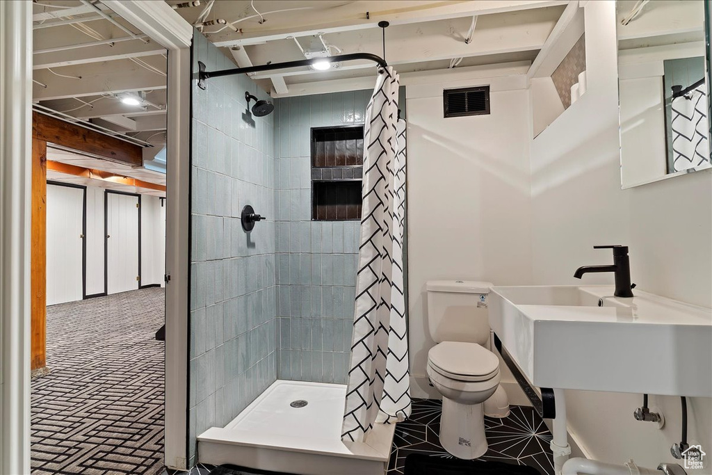 Bathroom featuring toilet and a shower with shower curtain