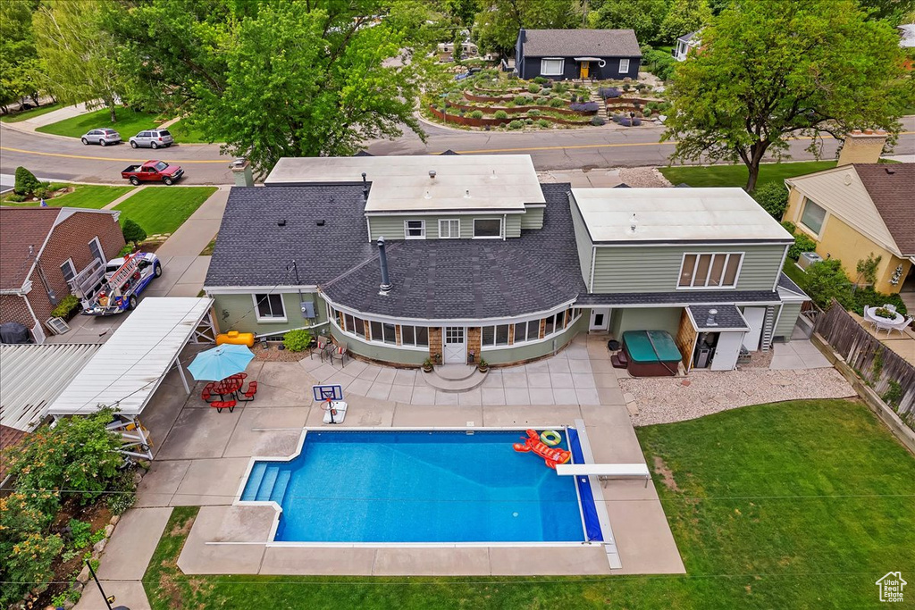 View of swimming pool with a patio area, a diving board, and a yard