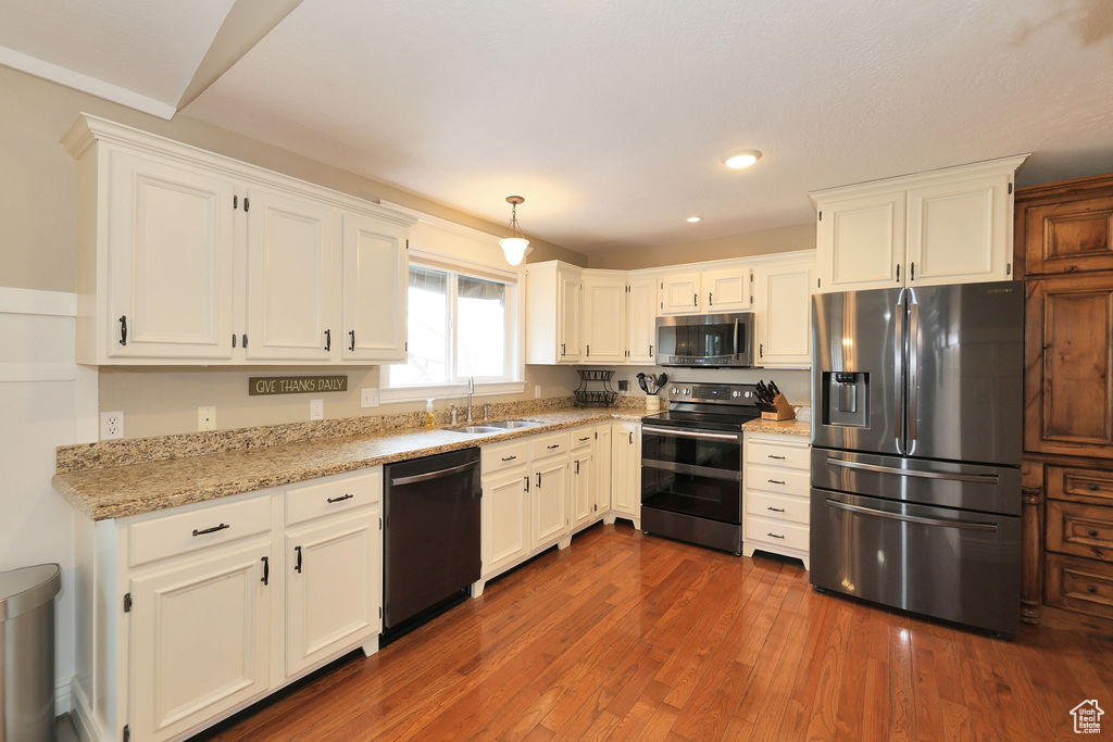 Kitchen featuring dark hardwood / wood-style flooring, white cabinetry, stainless steel appliances, and sink