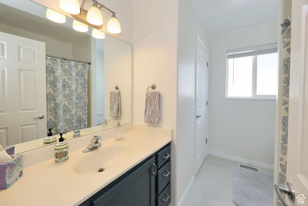 Bathroom featuring vanity with extensive cabinet space and tile floors