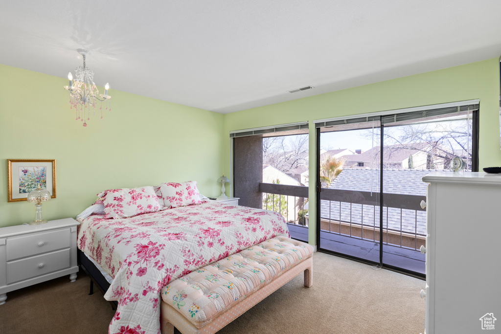Bedroom with a notable chandelier, carpet, access to outside, and multiple windows