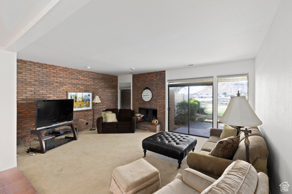 Tiled living room featuring brick wall and a fireplace