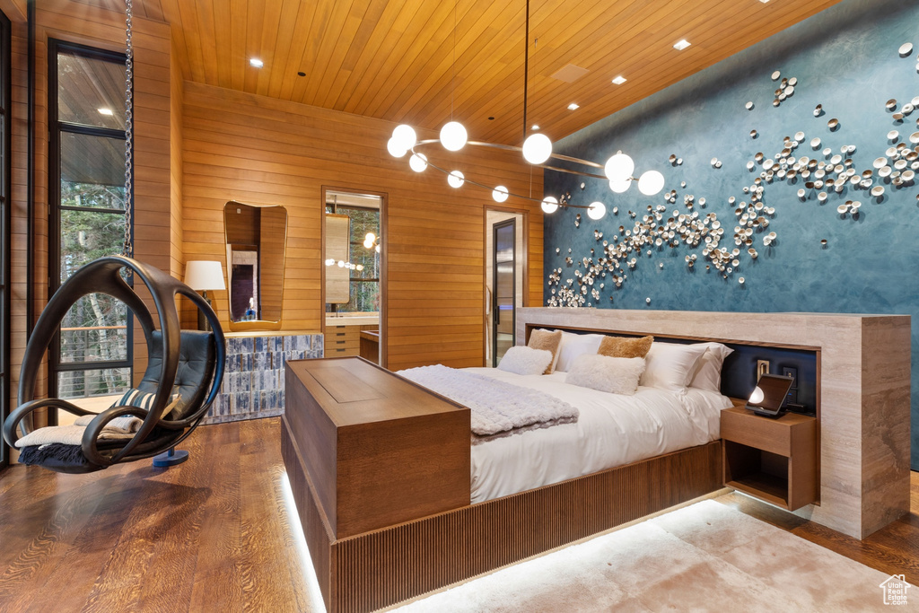 Bedroom with wooden walls, ensuite bath, wooden ceiling, and hardwood / wood-style floors