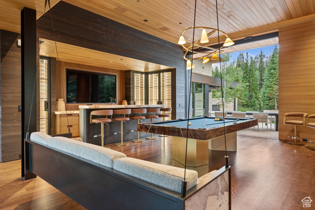 Exterior space featuring dark wood-type flooring, wood walls, wooden ceiling, and pool table