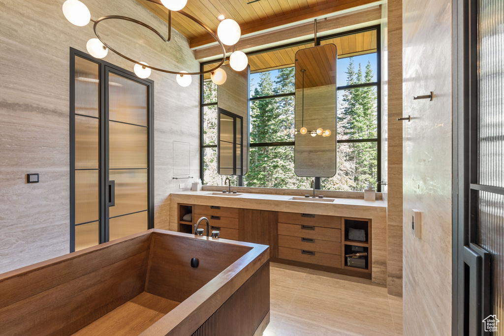 Bathroom with plenty of natural light, wood ceiling, tile walls, and double vanity