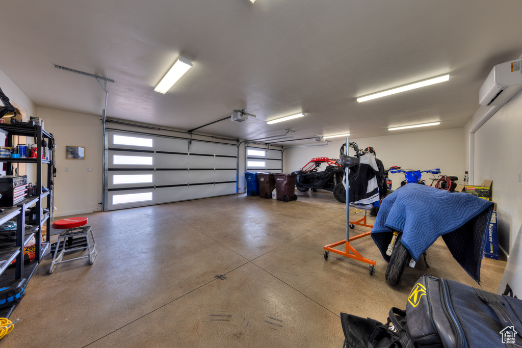 Garage with an AC wall unit and a garage door opener