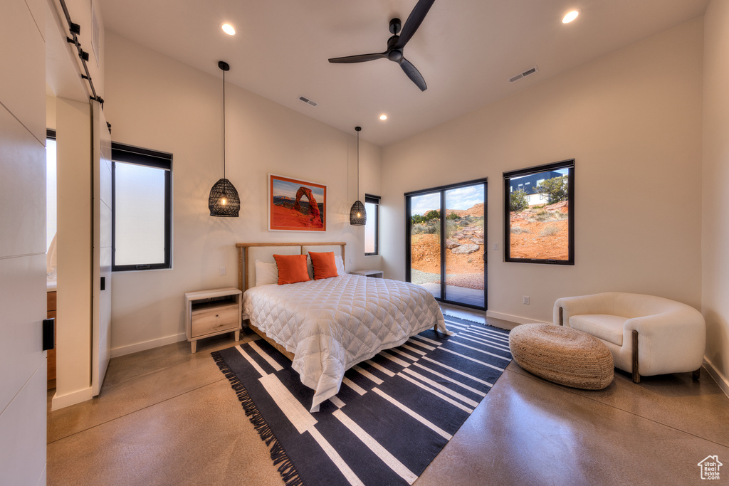 Bedroom featuring a barn door, access to outside, and ceiling fan