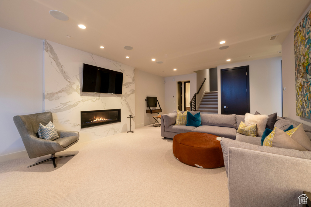 Living room featuring a high end fireplace and carpet
