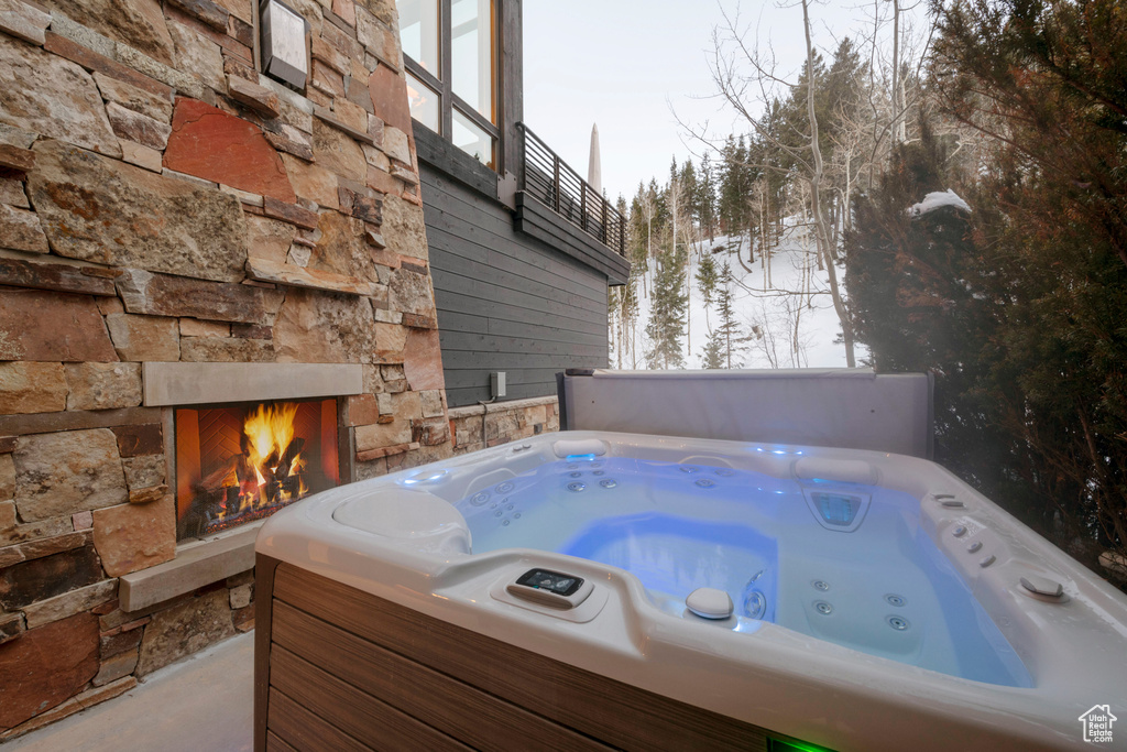 Exterior space featuring a hot tub and an outdoor stone fireplace