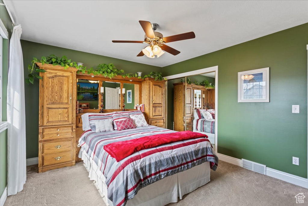 Bedroom featuring light carpet, a closet, and ceiling fan