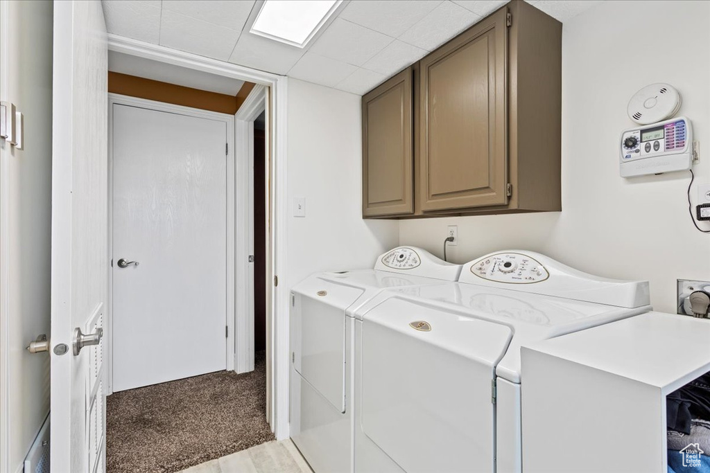 Laundry area with carpet, independent washer and dryer, and cabinets