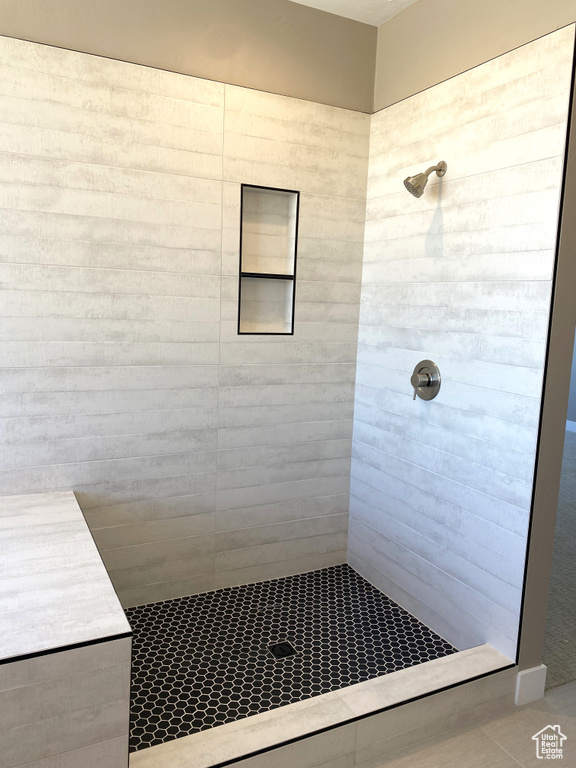 Bathroom with a tile shower and tile flooring