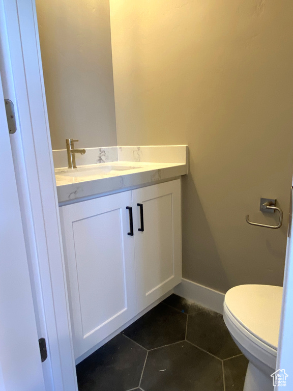 Bathroom with vanity, tile flooring, and toilet