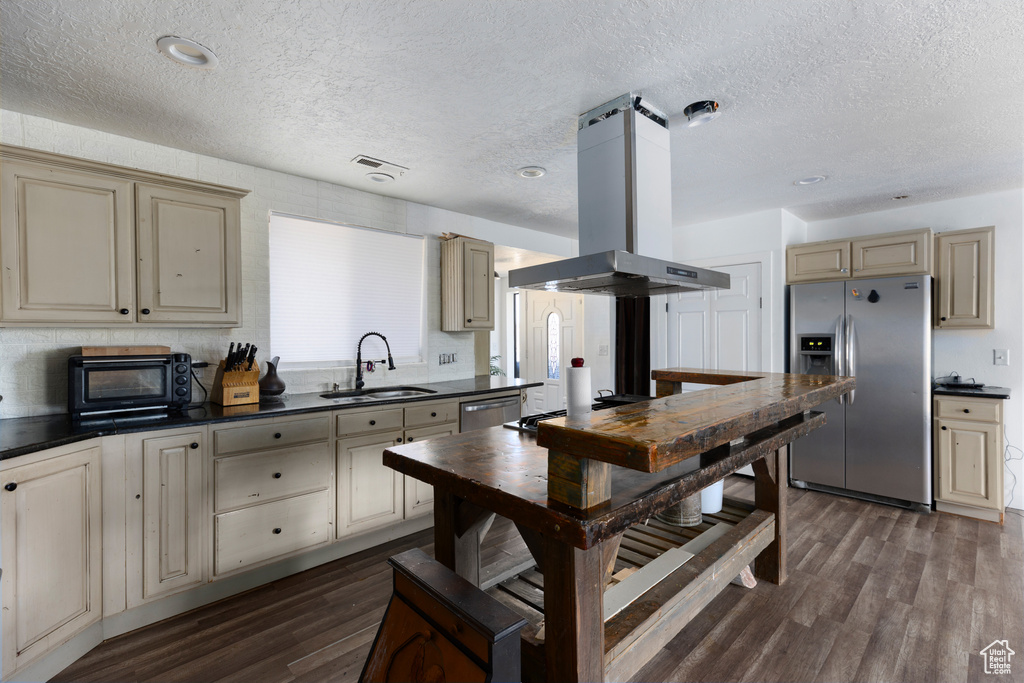 Kitchen featuring sink, a textured ceiling, dark wood-type flooring, stainless steel appliances, and island range hood