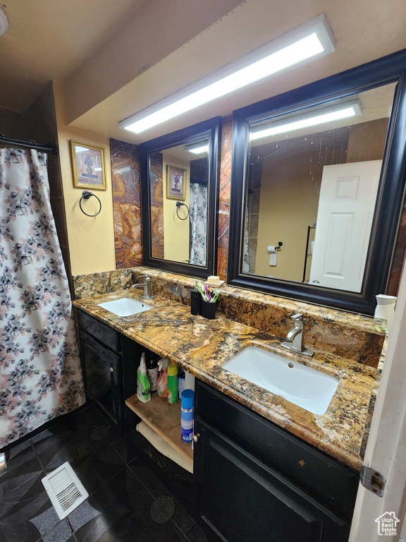 Bathroom featuring tile flooring and double sink vanity