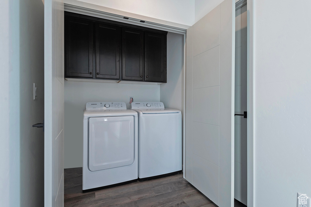 Laundry area featuring dark hardwood / wood-style flooring, cabinets, and independent washer and dryer