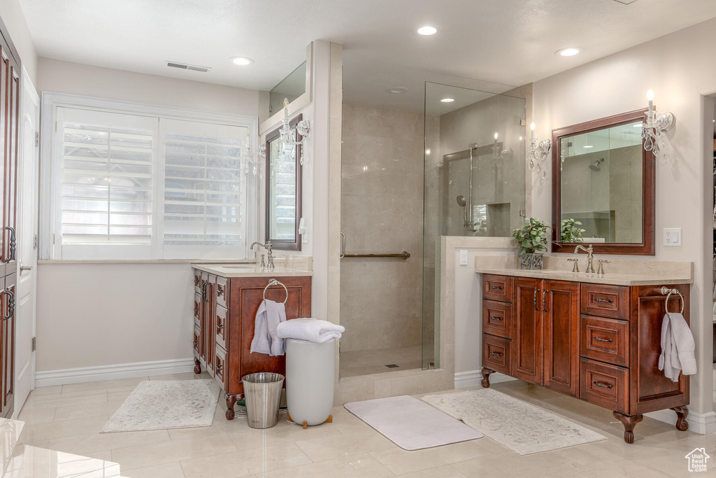 Bathroom featuring tile flooring, walk in shower, and dual bowl vanity