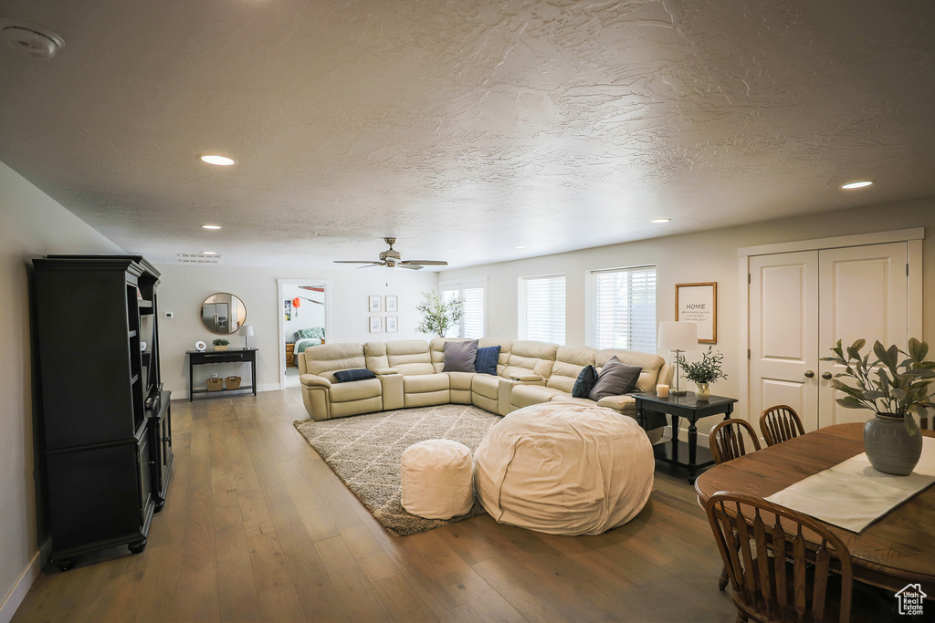 Living room featuring hardwood / wood-style flooring, a textured ceiling, and ceiling fan