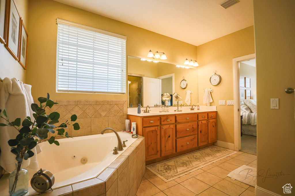 Bathroom with tile flooring, double sink vanity, and a wealth of natural light