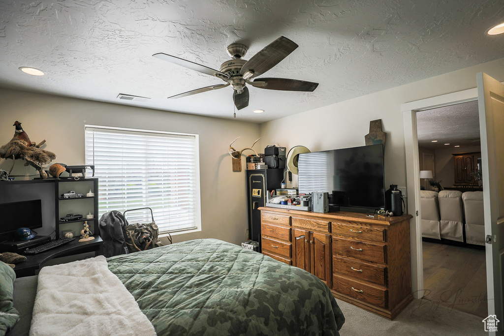 Bedroom with washing machine and dryer, a textured ceiling, dark colored carpet, and ceiling fan